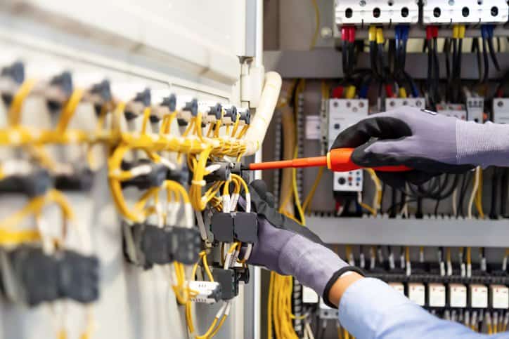 Electricians work to connect electric wires in the system, switchboard, electrical system in Control cabinet that adheres to electrical loop check steps in IEC 62382:2012.