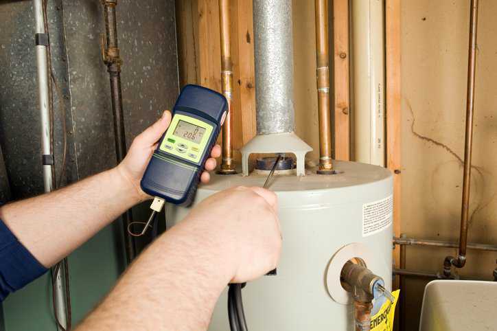 Technician repairing a draft hood in a gas furnace that adheres to safety procedure in CSA ANSI Z21.12-1990 (R2020).