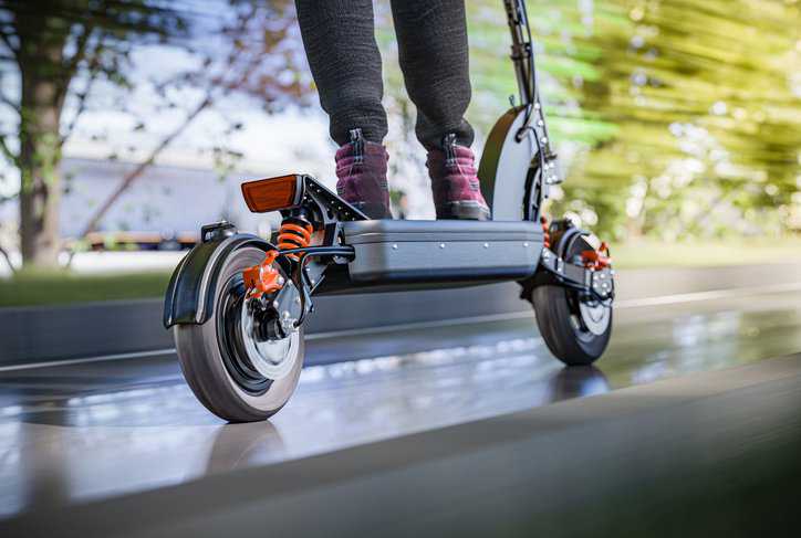 Electric scooter fast ride through the city, adhering to ASTM F2641-23.
