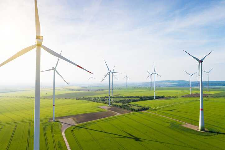 Aerial view of wind turbines producing renewable energy that adhere to design requirements in IEC 61400-1:2019.