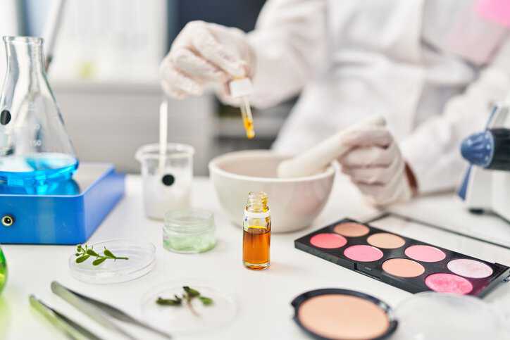 Scientist performing microbiological examinations of cosmetic make-up products in a laboratory that adhere to ISO 17516:2014.