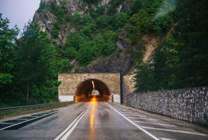 Empty highway tunnel with luminaires and lighting that adhere to ANSI C136.27-2021.