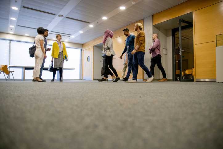Students leaving classroom, feet walking safely on commercial floor mat.