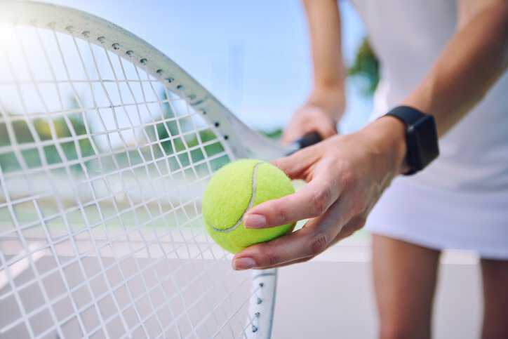 Professional athlete holding a tennis racket, adhering to ISO 11416: 1995, and tennis ball to make a serve.