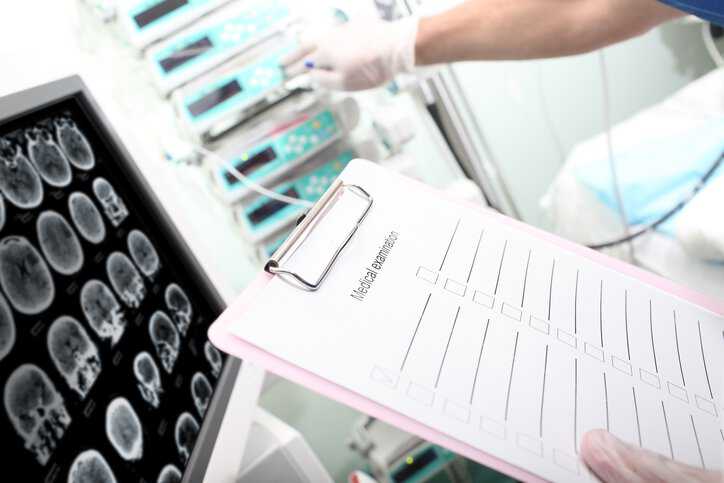 A dentist examining a patient's digital dental radiographs that adhere to ADA 1094-2020.