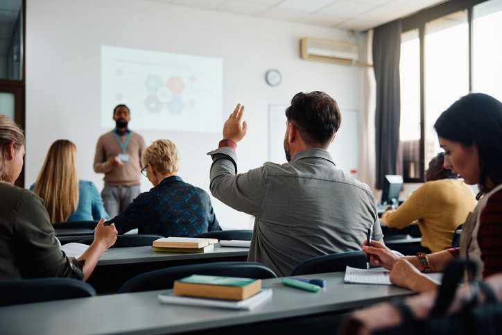 Student raising hand in certificate learning training class.