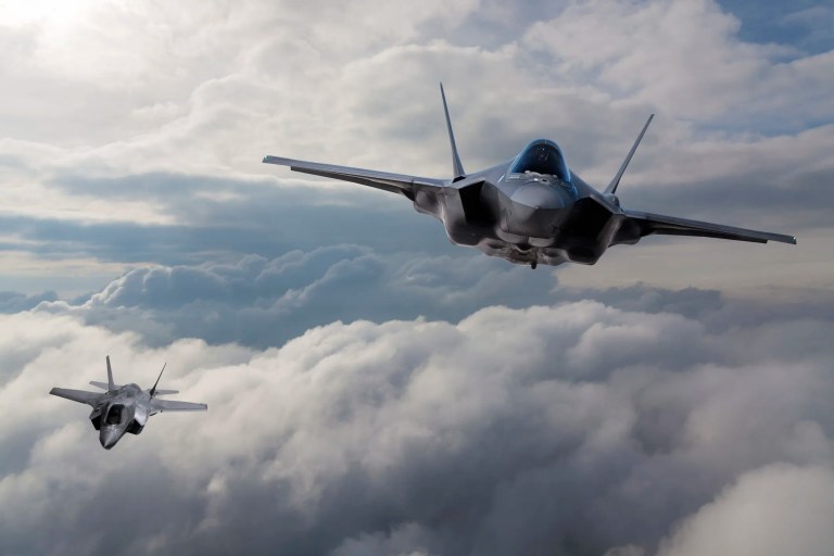 F-35 fighter jets flying over clouds