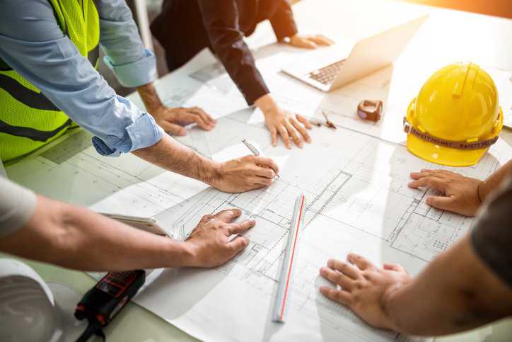 Team of engineers drawing a piping and instrumentation (P&ID) diagram for a chemical plant.