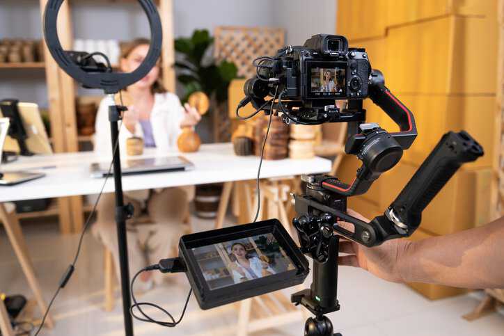 Behind the scenes of a woman entrepreneur live streaming to sale craft products to customers via filming professional camera adhering to IWA 41: 2023 livestreaming guidelines.