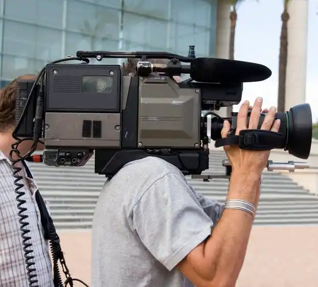 Cameraman shooting film on betamax outside