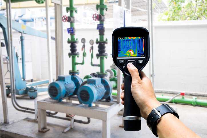 Technician use thermal imaging camera to check temperature in factory with a pyrometer that adheres to SAE AMS 2750H-2024.