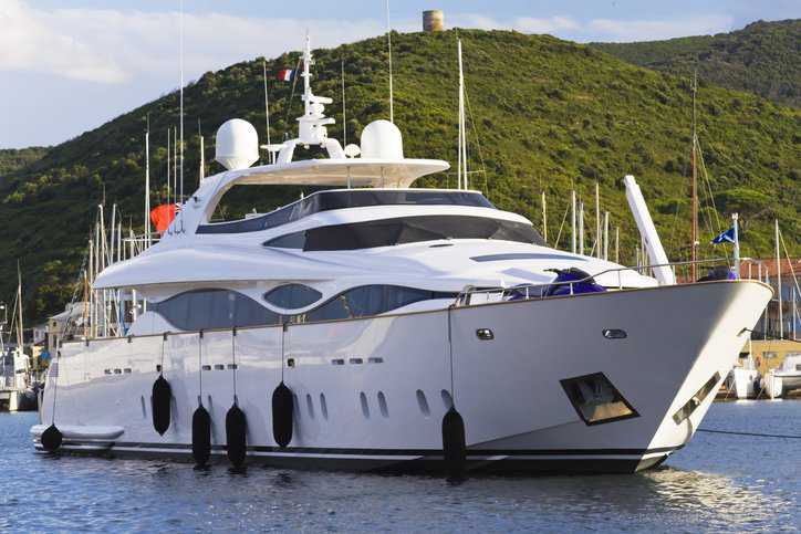 Very large luxury yacht, adhering to ISO 11336-1:2023, that is docked on the ocean.