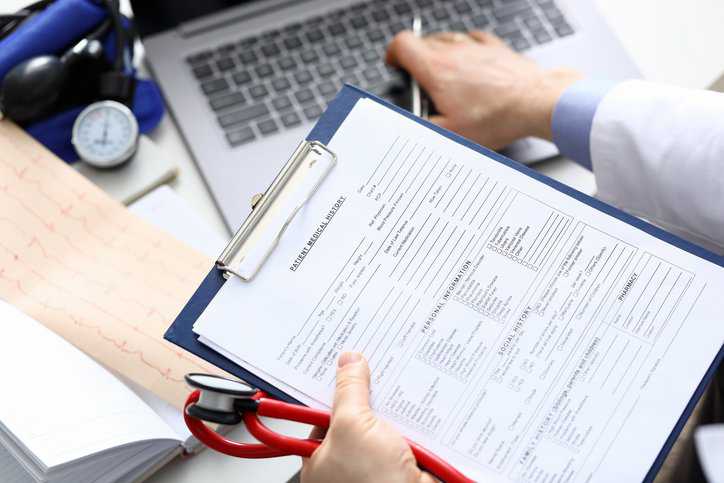Doctor fills out patient's data, taking into account patient diagnoses. Healthcare facility adheres to ANSI/NEMA SC 1-2020 in order to safeguard patient data and privacy.