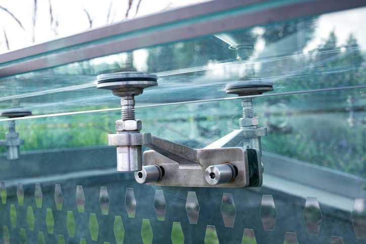 A close up of a glass pergola steel roof that is mounted and bolted by unified screw inch thread fasteners that adhere to ASME B1.1-2024.
