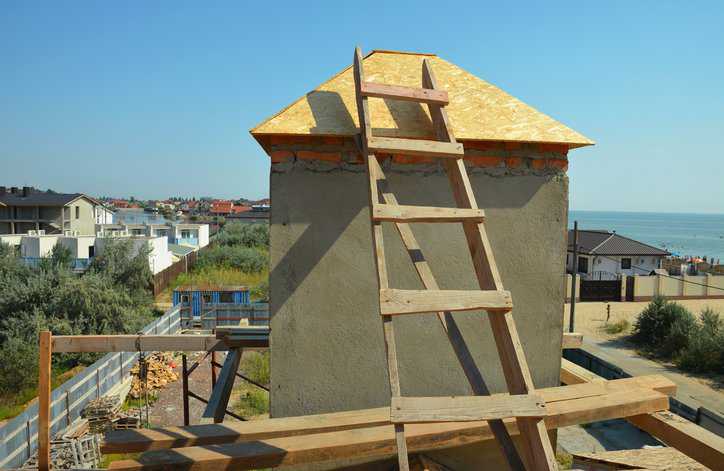 Building construction of a house with a focal point of a job-made wooden ladder that adheres to ANSI ASC A14.4-2018.