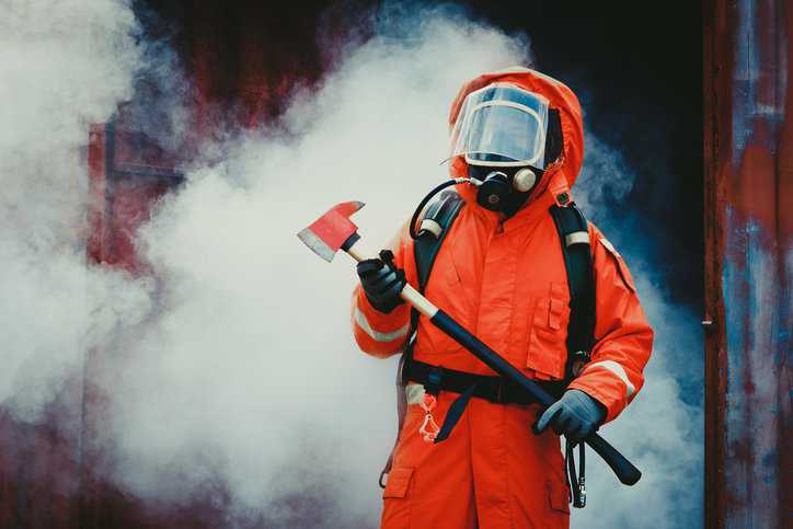 Firefighter wearing a smoke hood that adheres ANSI/ISEA 110-2009, assuring respiratory protection.