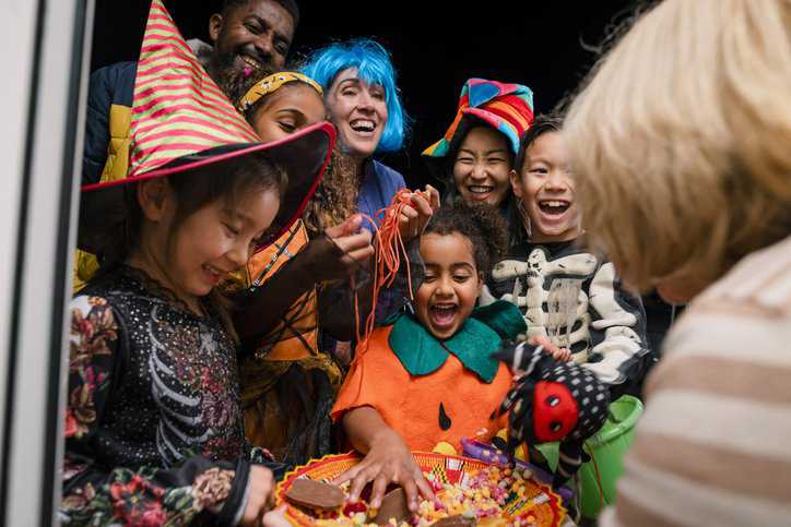 Happy trick-or-treaters getting candy, that underwent a quality control process, during Halloween.