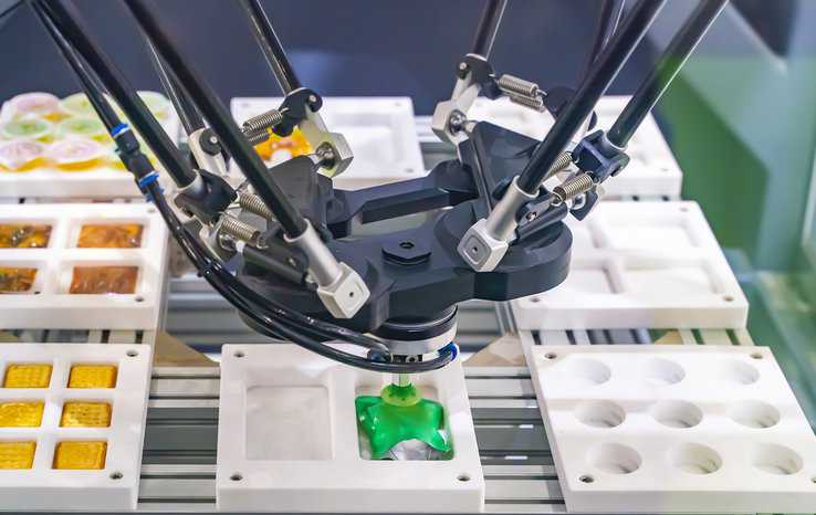 Automatic robot with vacuum suckers and conveyor in Production of candy for the food industry, assuring food safety and high quality standards are in place.