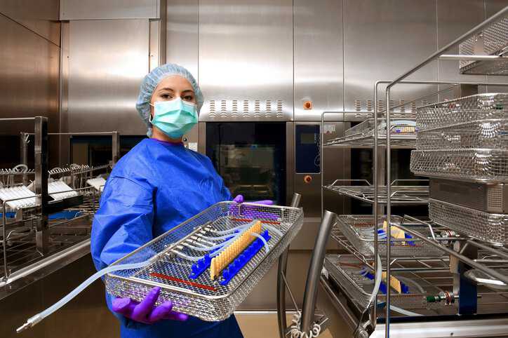 Medical hygiene technician working in a hospital to sanitize medical devices with quality water adhering to ANSI/AAMI ST108:2023 specifications.