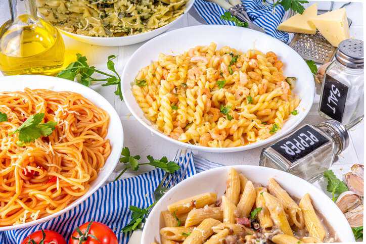 Variety of alimentary pasta on a dinner table that adheres to ISO 7304-1:2016 cooking quality specifications.