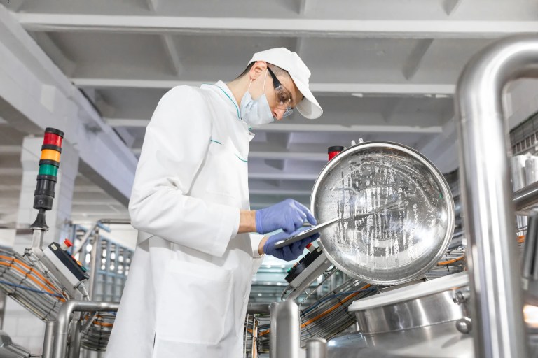 A food safety inspector checking the sanitation of commercial cooking equipment to ensure compliance with NSF/ANSI 4-2025 standards for food safety and hygiene.