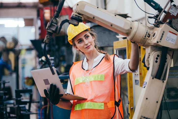 Female industrial engineer inspecting the safety of the machines and control systems in an industry manufacturing factory, assuring adherence to ANSI B11.26-2024.