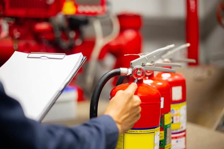 Engineer checking Industrial fire control system to assure fire protection in the event of a fire, adhering to ISO 23932-1:2018 fire safety engineering guidelines.