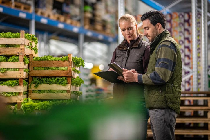 Food safety inspector reviewing production for standard (ISO 22000 food safety) compliance.