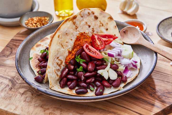 A plant-based meal of beans and corn tortilla plated, featuring the diet of the Blue Zone: Nicoya Peninsula, Costa Rica.