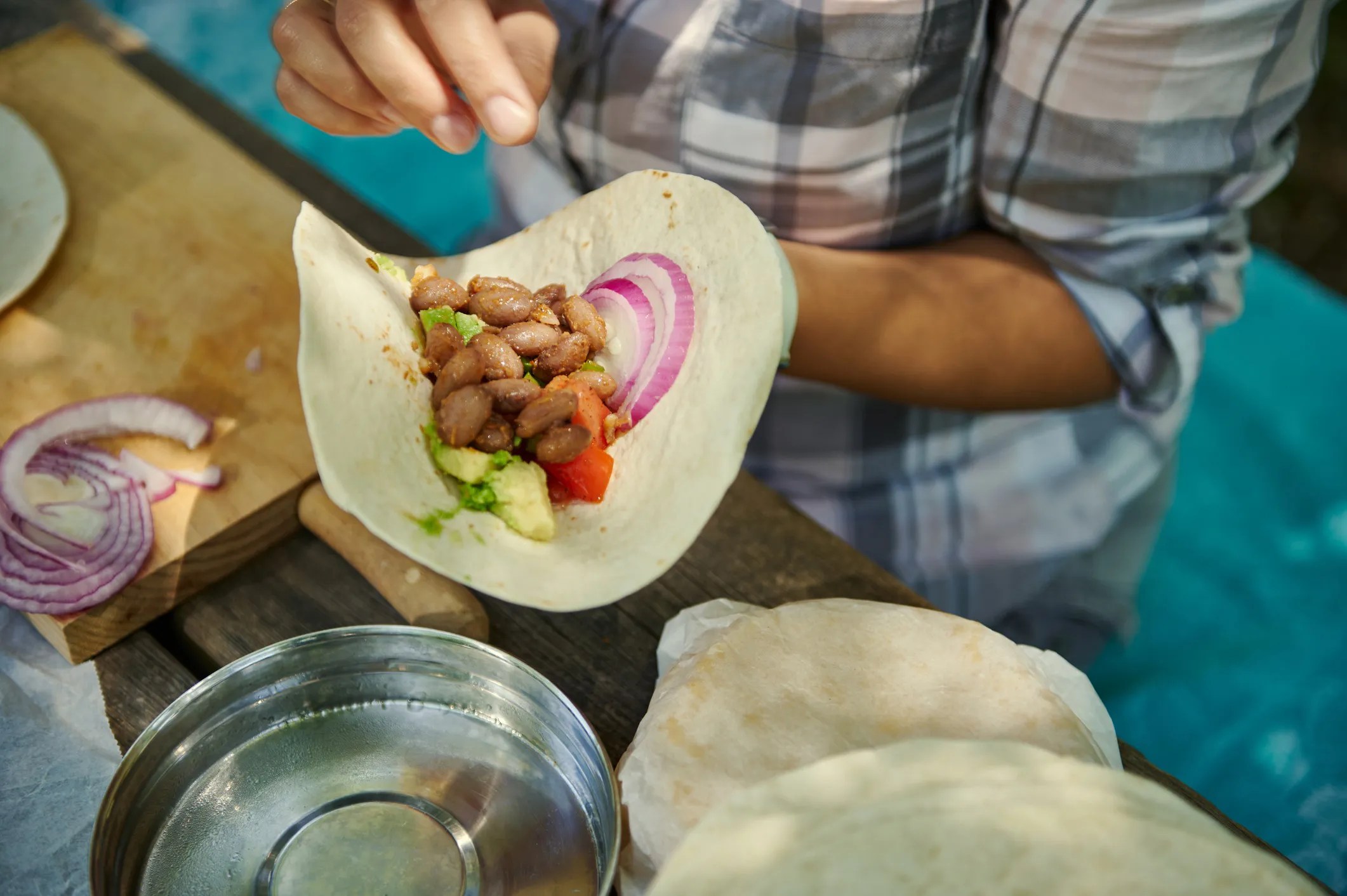 A woman from the  Blue Zone, Nicoya Peninsula, Costa Rica preparing a plant-based meal of beans and corn tortilla.