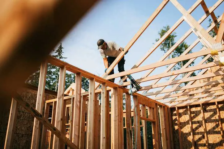 Workers building the frame of a residential home that complies with the 2024 International Residential Code (ICC-IRC 2024).