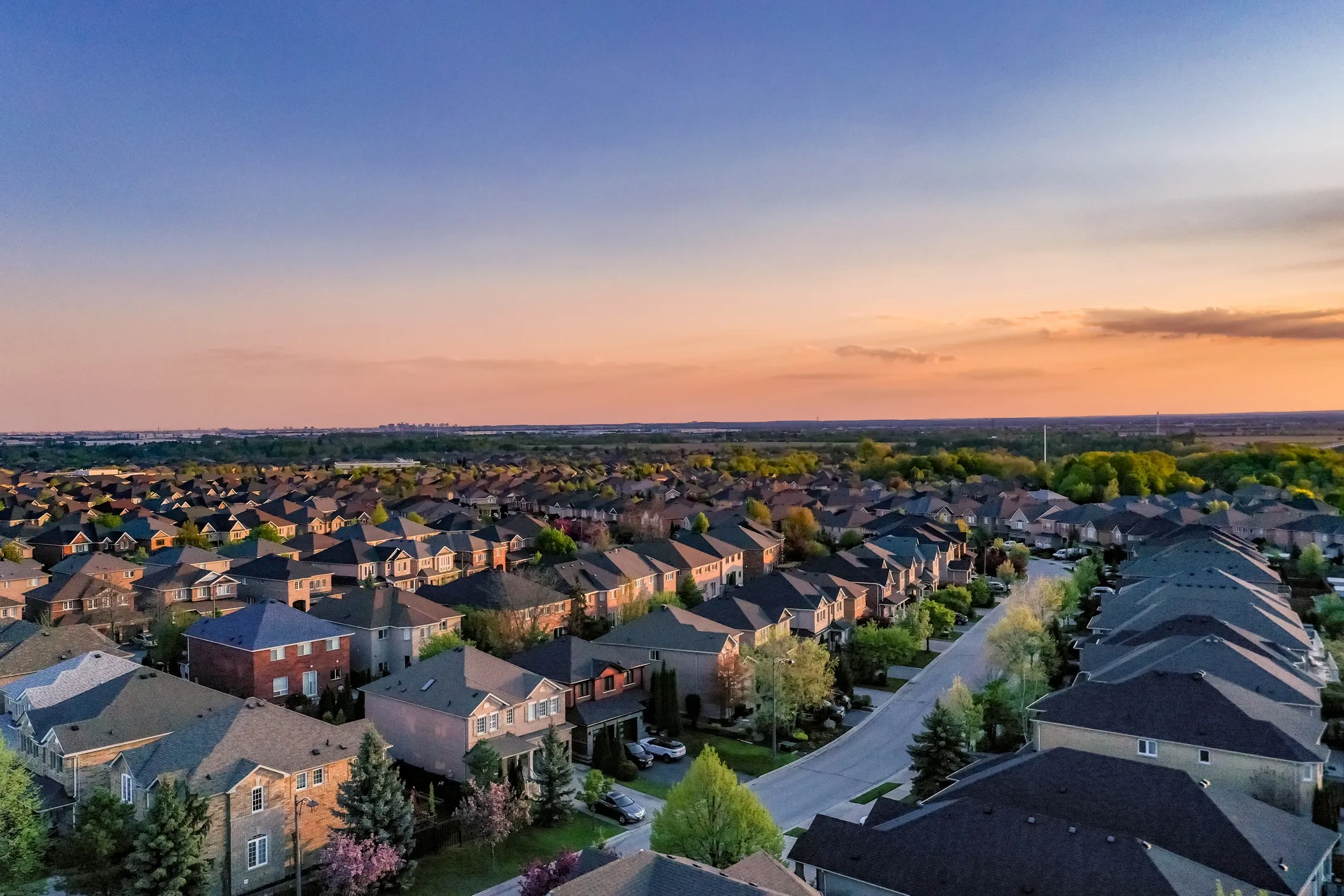 Aerial view of residential homes during sunset that adhere to the 2024 International Residential Code (ICC-IRC 2024).