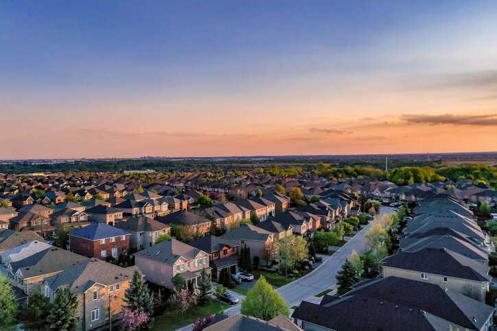 Aerial view of residential homes during sunset that adhere to the 2024 International Residential Code (ICC-IRC 2024).