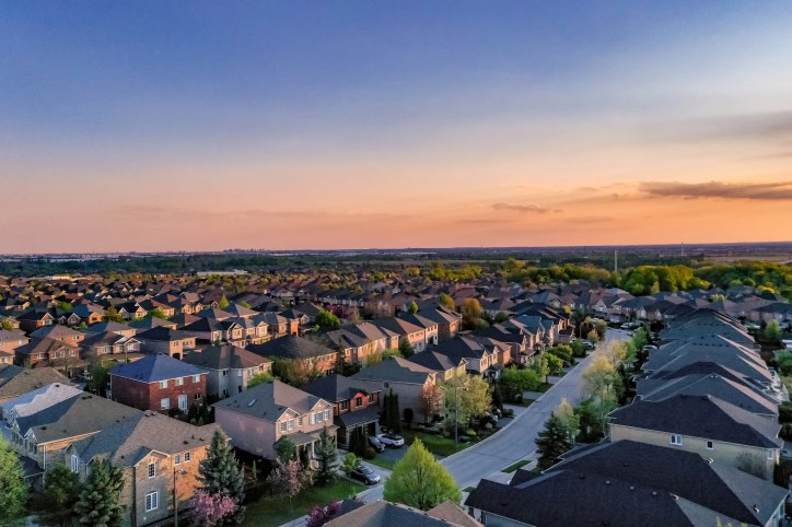 Aerial view of residential homes during sunset that adhere to the 2024 International Residential Code (ICC-IRC 2024).