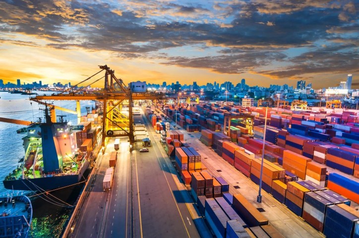 Container Cargo freight ship with working crane bridge in shipyard that displays the concept of global/international trade.