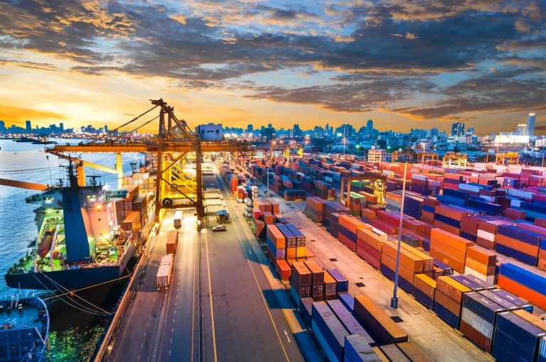 Container Cargo freight ship with working crane bridge in shipyard that displays the concept of global/international trade.