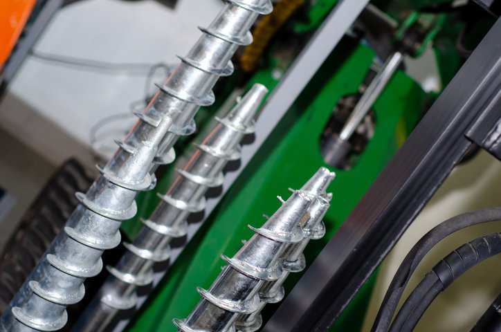 Close up of metallic drive screw used for manufacturing that adheres to ASME B18.6.3-2024.