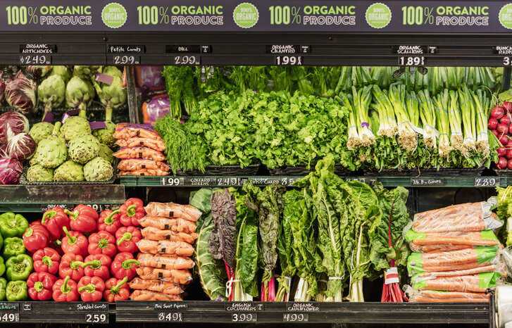 Organic vegetables in the produce aisle of a supermarket.