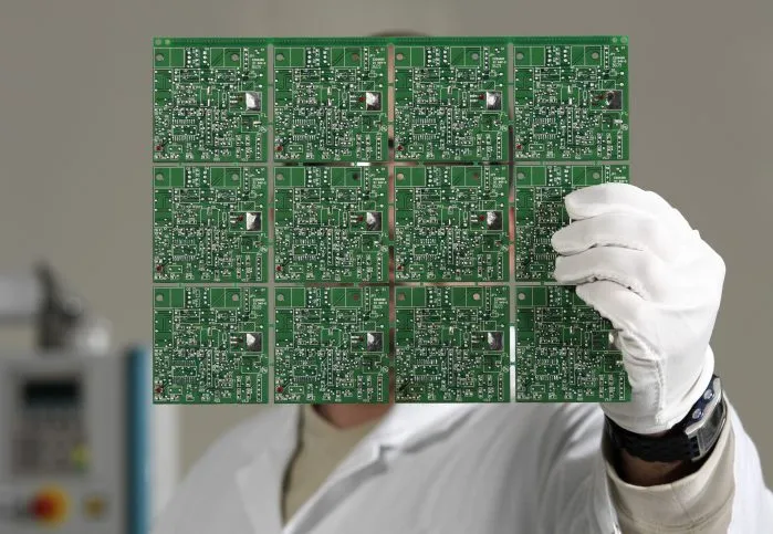 Electronics engineer controlling a printed circuit board that adheres to design specifications outlined in IPC 2152-2009.