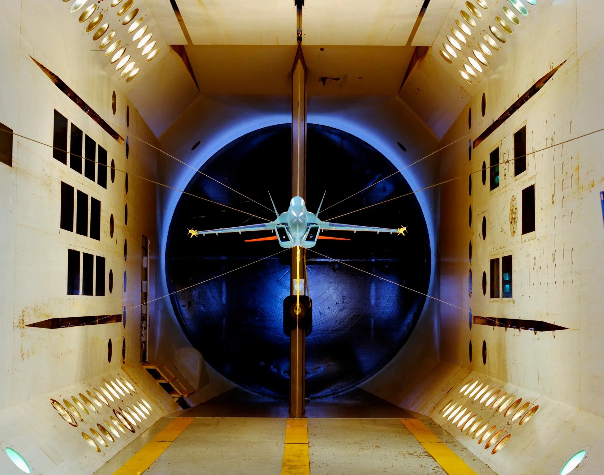 Wind tunnel test for a plane being conducted in a calibration laboratory.