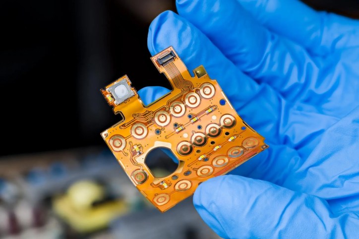 Close-up of an electronic flexible cable with connector on bent plastic circuit board that adheres to IPC-9257.