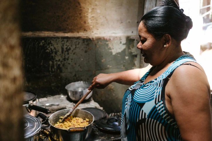 A woman using a clean cookstove, adhering to ISO 19869:2019, to make dinner.