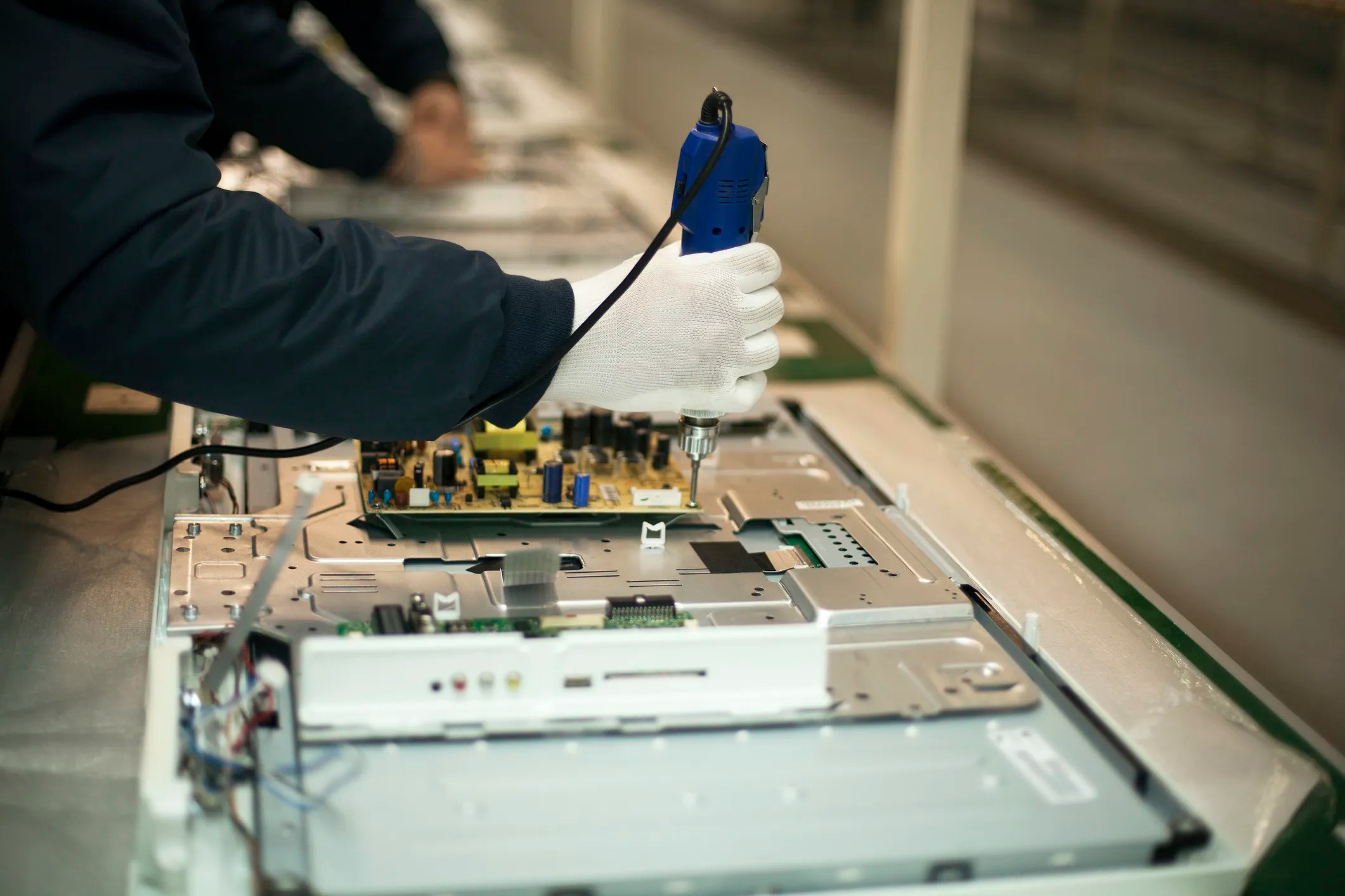 Circuit board being manufactured in a factory that has electrostatic discharge (ESD) awareness symbols that adhere to ANSI/ESD S8.1-2021.
