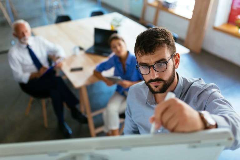 Employees at a startup developing a business plan that utilizes ISO 22301 and ISO 31000 frameworks.