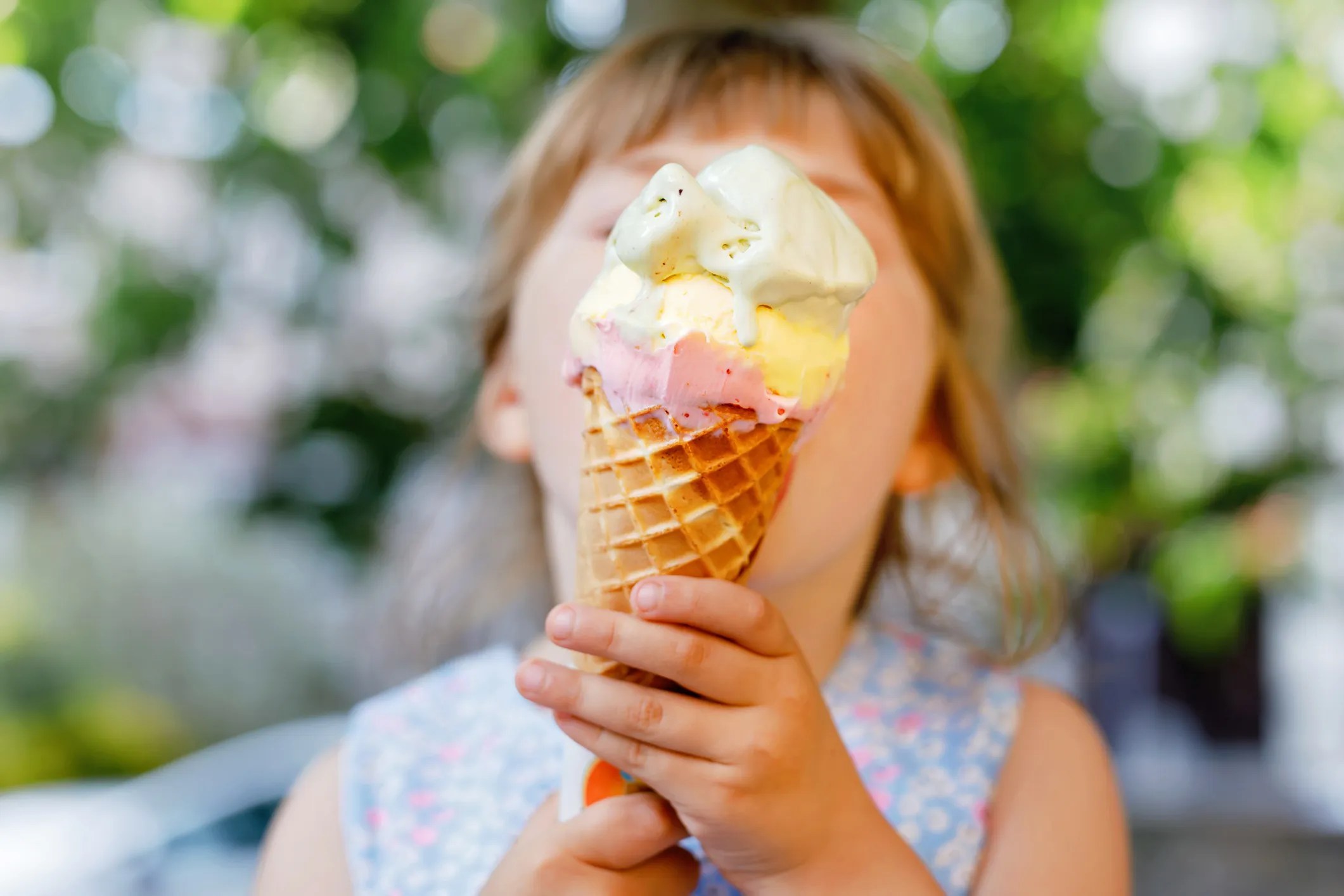 Little girl licking an ice cream cone that adheres to ISO 22000 food safety requirements.