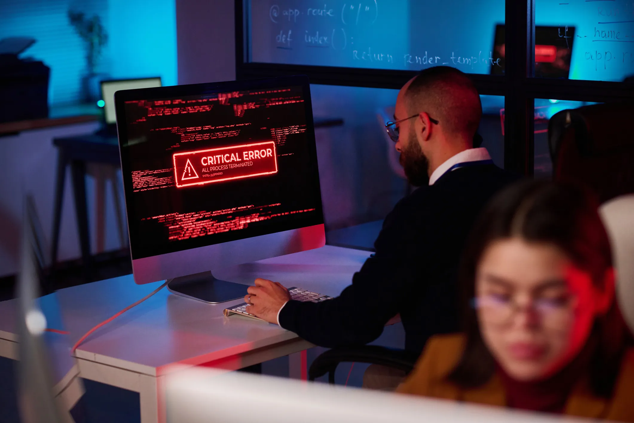 An employee doing work on his computer that has a critical error warning message in red that complies to ANSI Z535.7-2024.