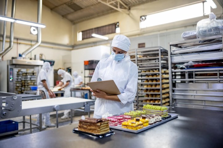 Quality management audit being conducted at an industrial bakery that adheres to ISO 22002-1:2025.