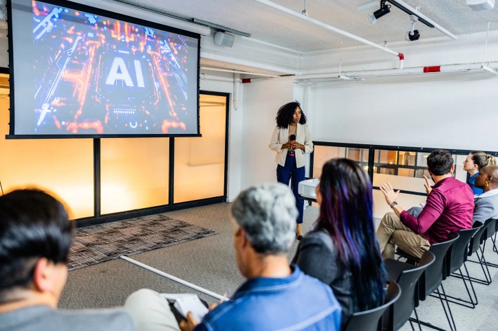 Coworkers in a tech company discussing AI terminology as specified by the INCITS/ISO/IEC 22989:2022 (2023) standard.