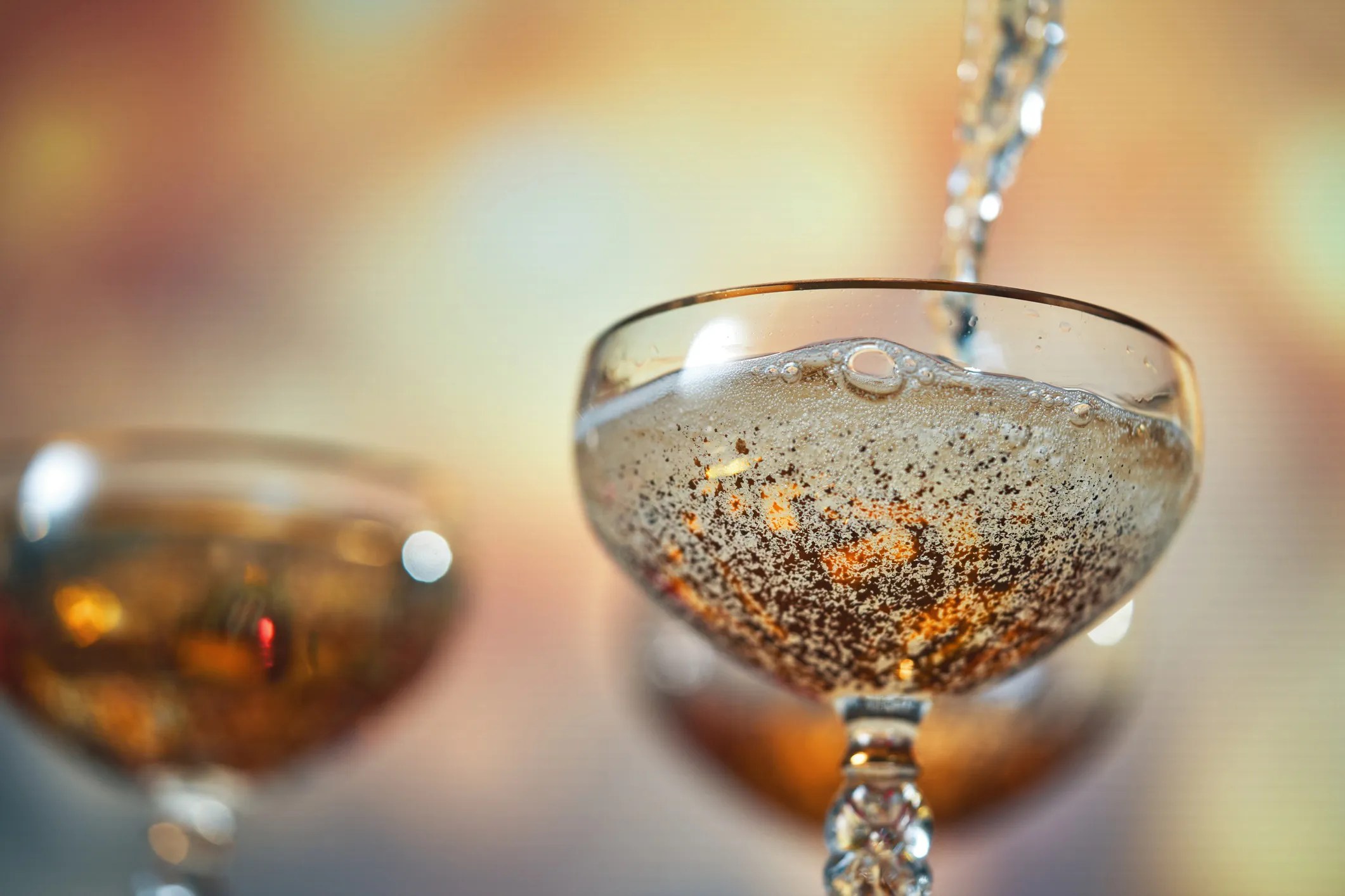 Champagne bubbles rising in a glass during a celebration, reflecting the drink’s historic connection to luxury, tradition, and festive occasions.