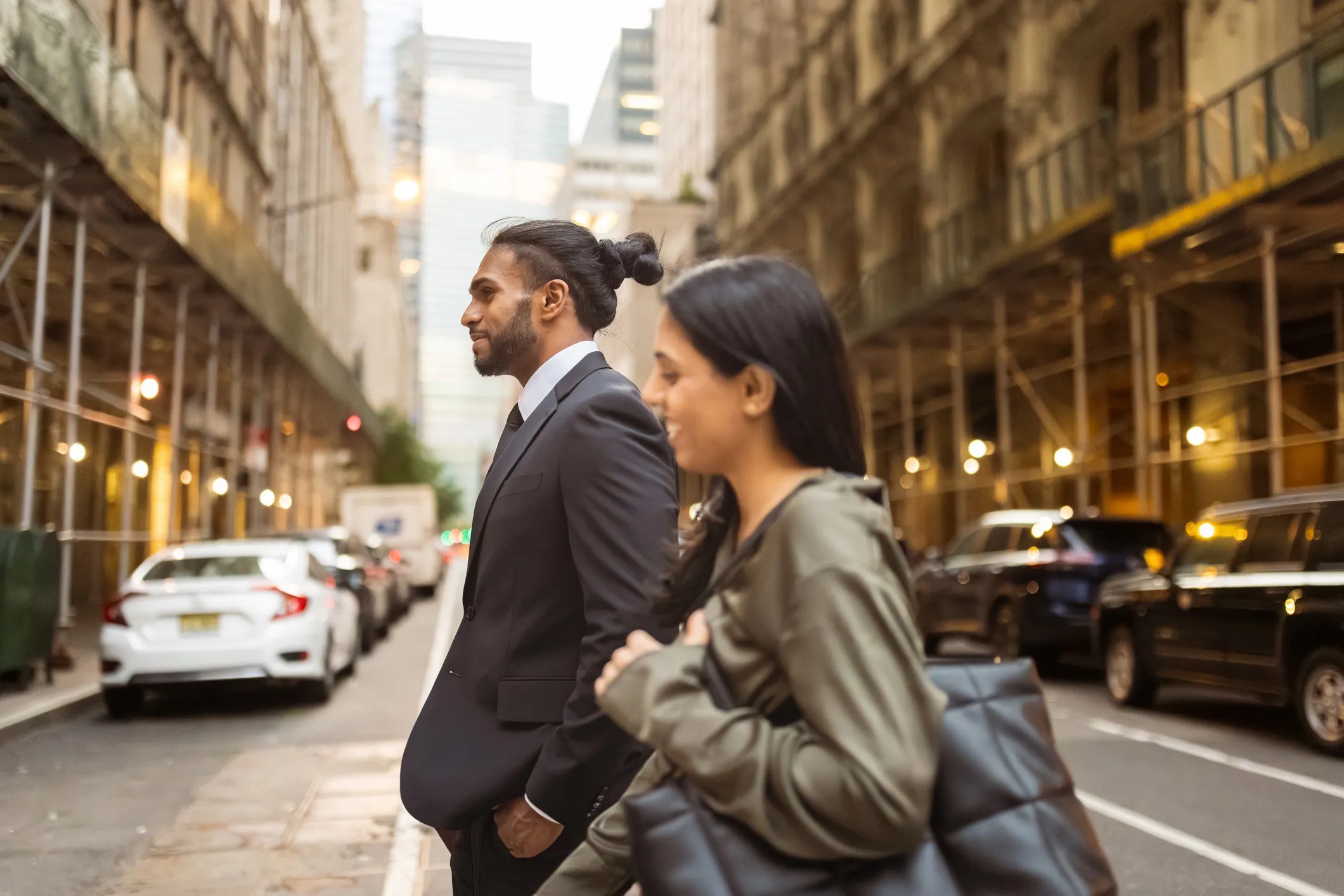 Rows of sidewalk sheds lining a busy New York City street, protecting pedestrians beneath aging building facades.